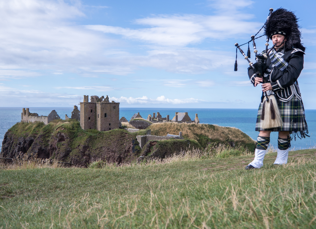 Foto da Escócia com um homem tocando gaita de foles vestindo kilt