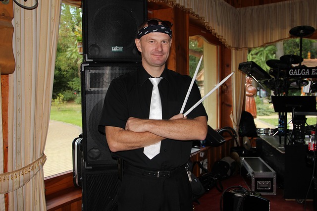 Baterista segurando baqueta com bandana na cabeça.