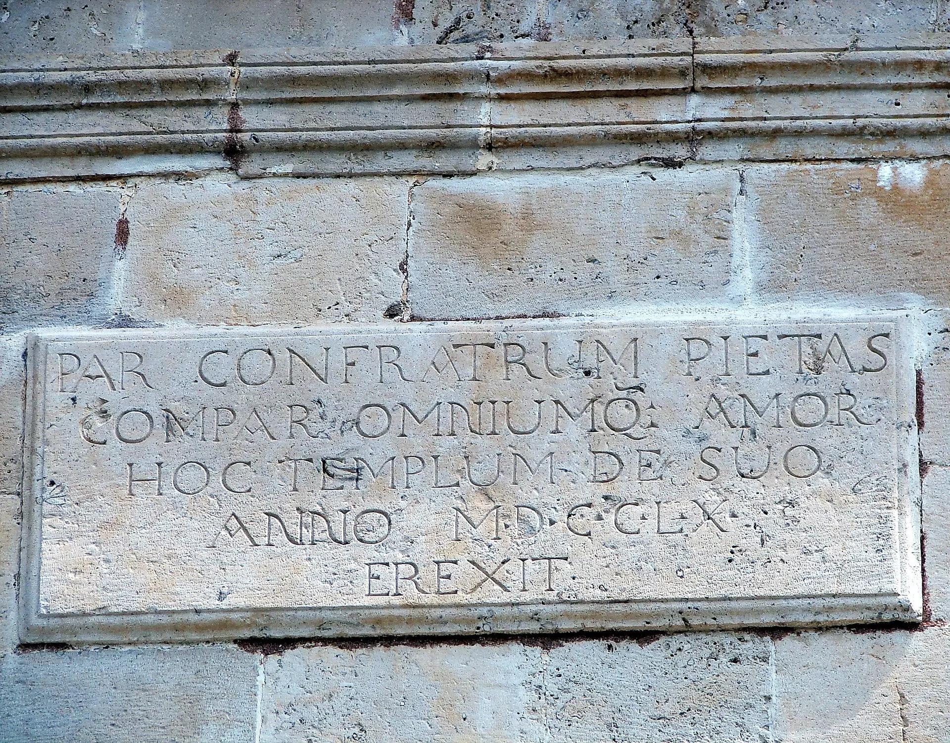 Pedra com letras em latim esculpidas.