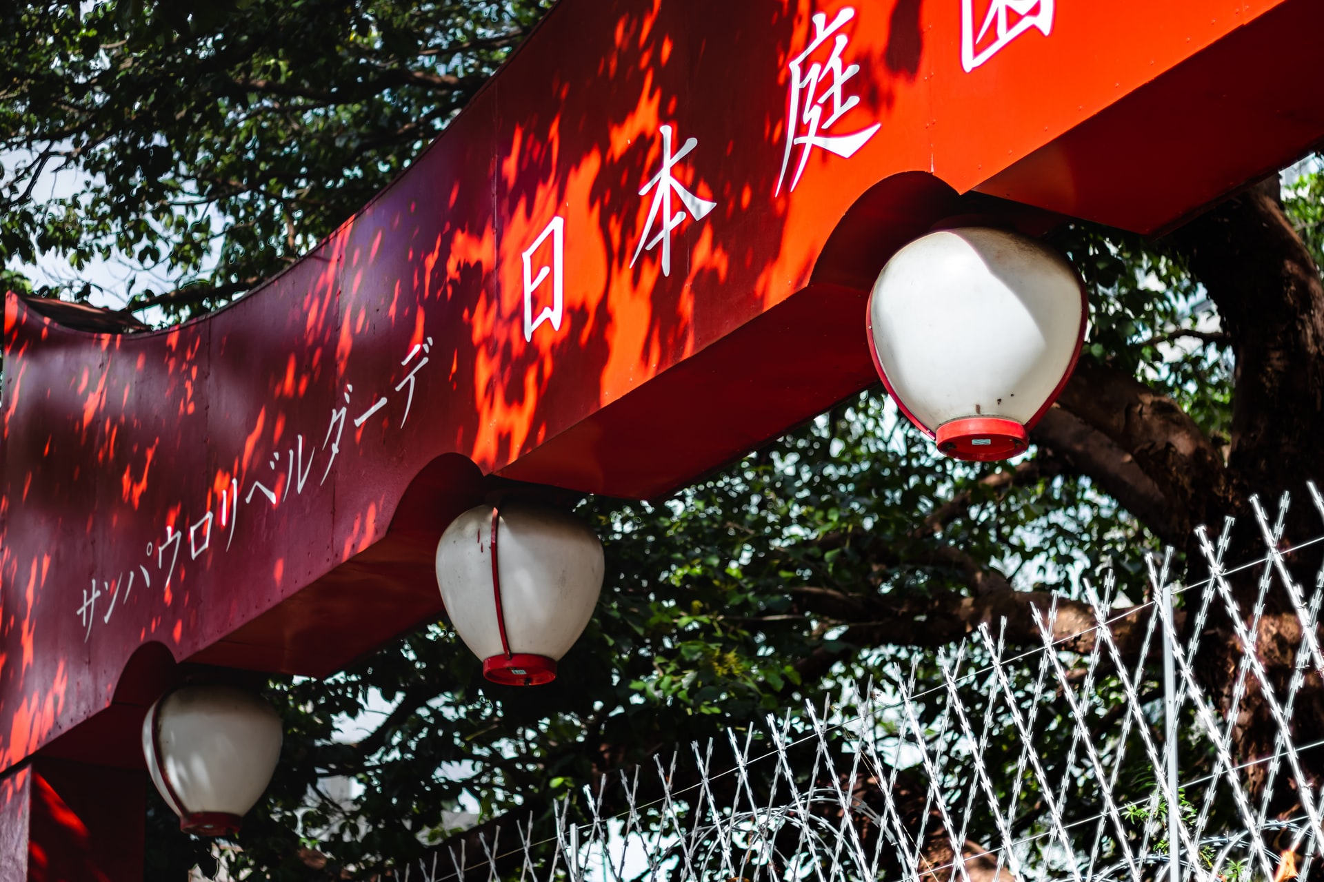placa na entrada da liberdade com as lanternas japonesas