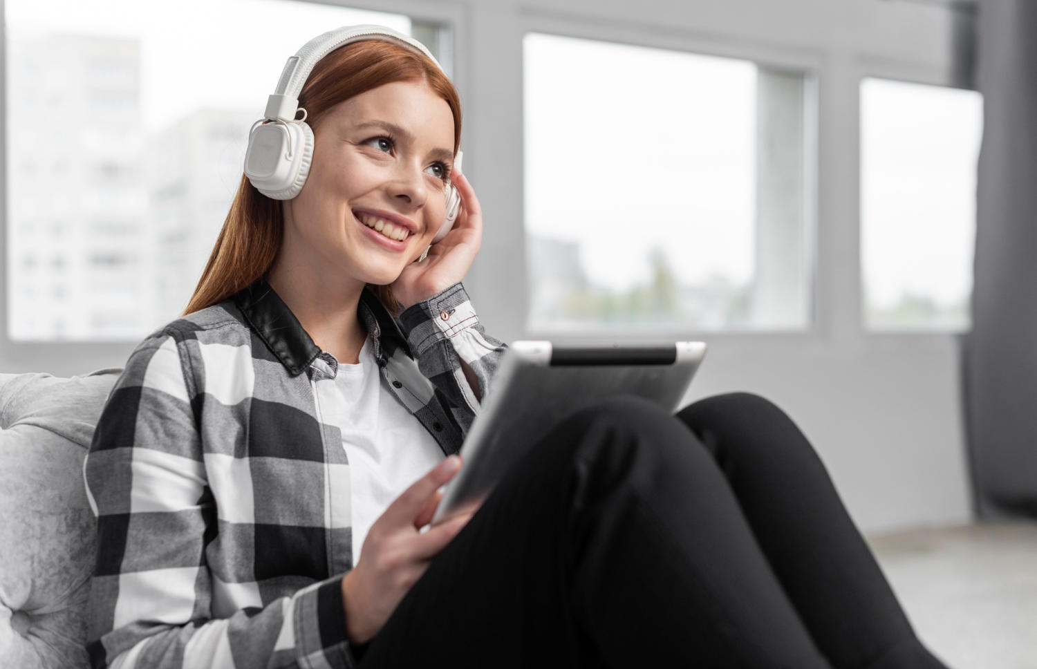 Mulher ouvindo podcast pelo fone e tablet. 