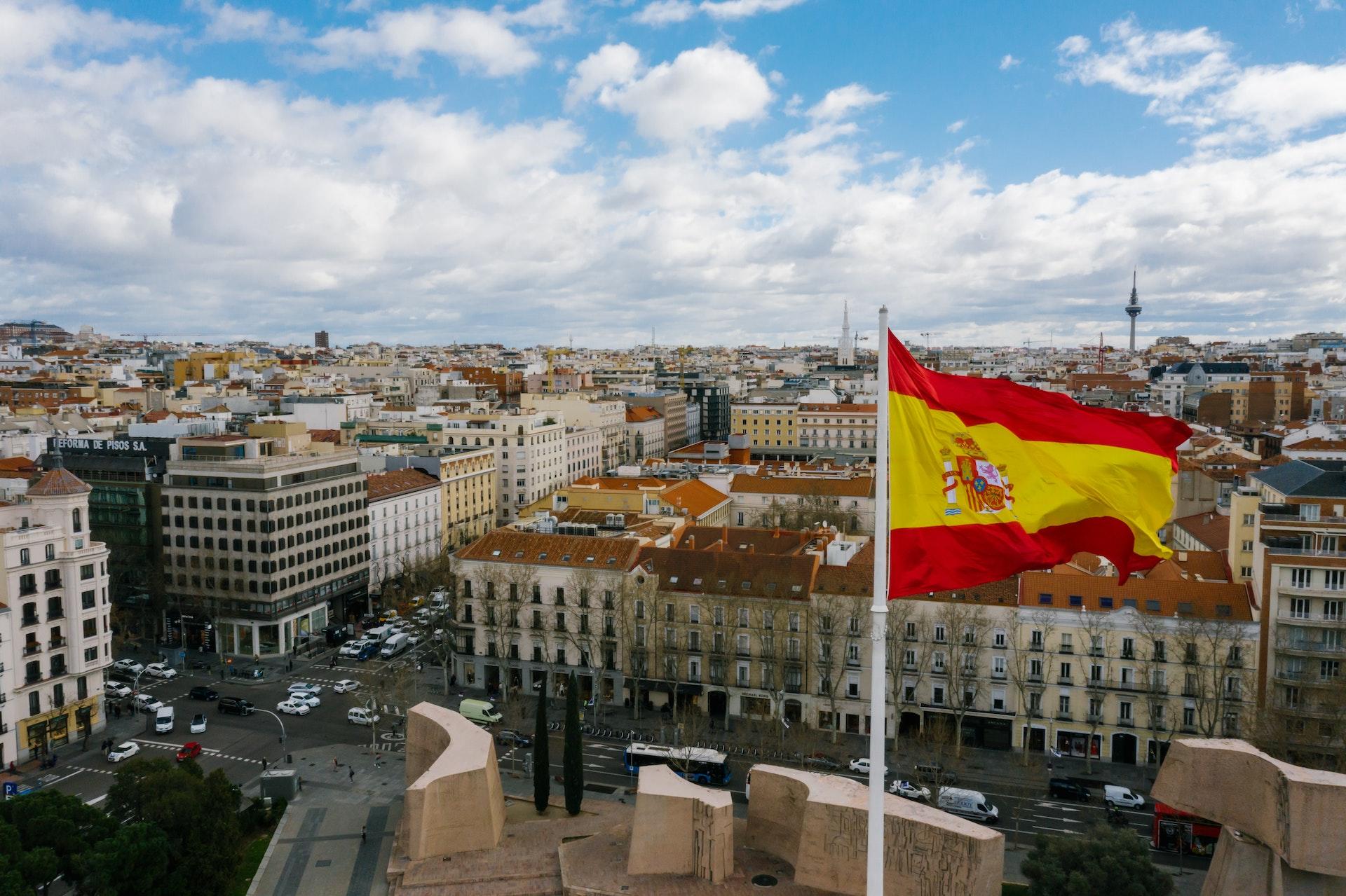 Paisagem urbana da Espanha, com uma bandeira em destaque.