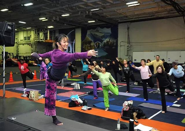 Professora de yoga e alunos em postura do dançarino.