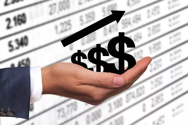 Uma mão segura uma ilustração com símbolos de dólar crescentes.