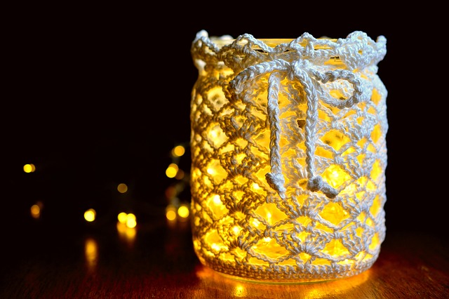 Vela sobre a mesa com uma capa feita de crochê.