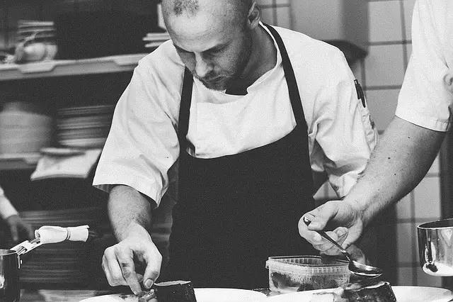 Homem cozinhando em restaurante.