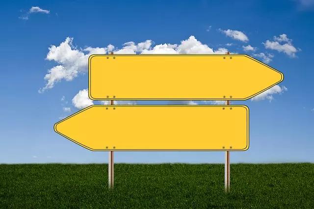 Duas placas amarelas de sinalização que apontam para direções opostas.