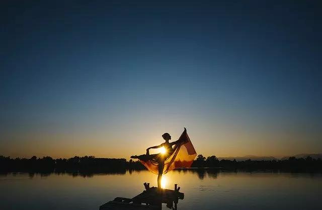 Mulher dançando com um véu no pôr-do-sol.