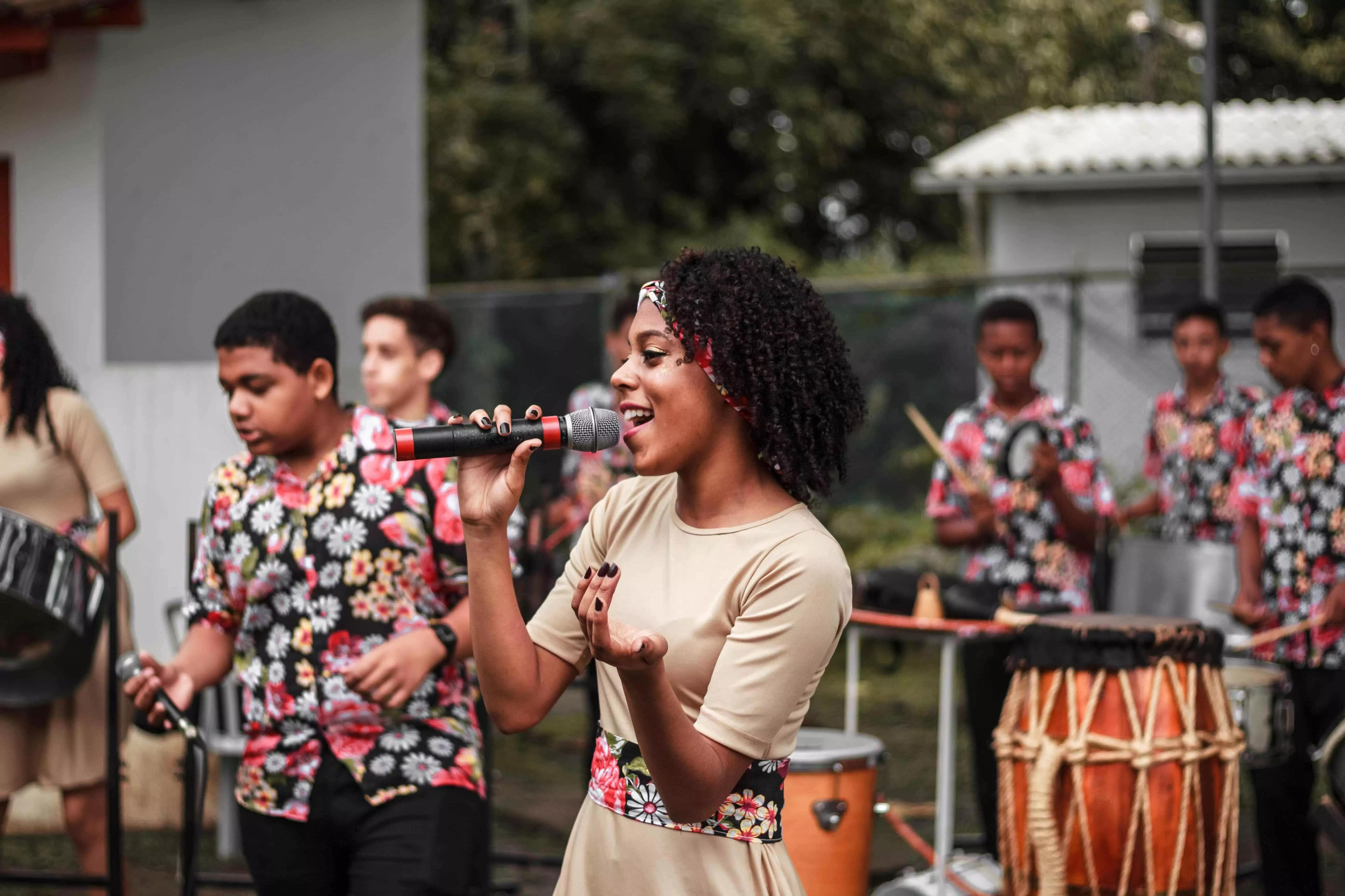 Uma mulher cantando na rua com uma banda