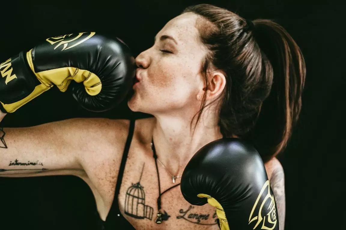 mulher beijando luvas de boxe