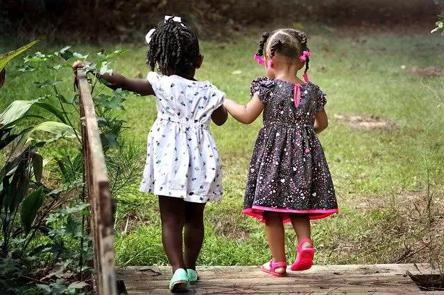 Duas meninas brincando de mãos dadas.