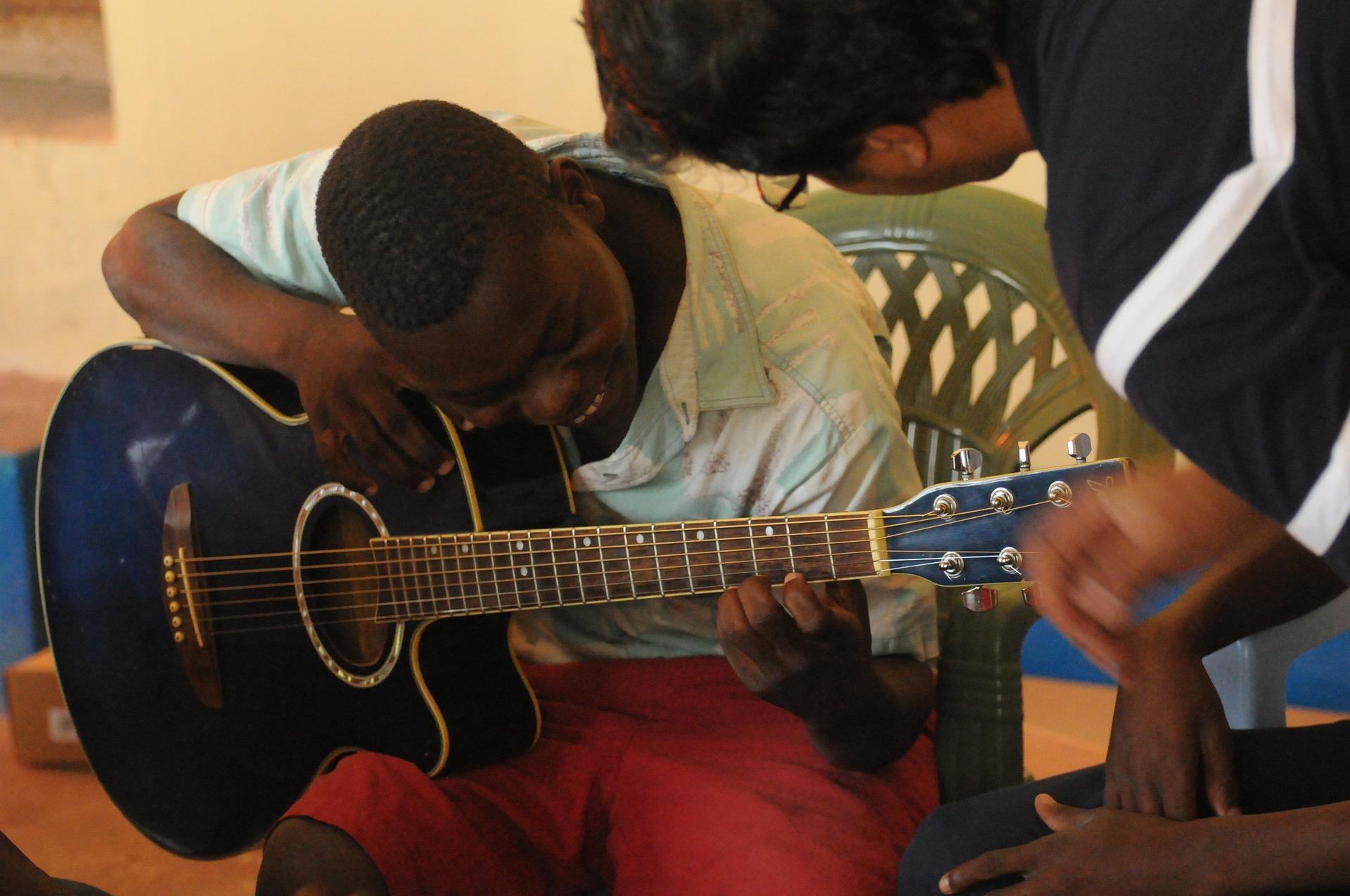 Adolescente tendo aula particular de violão