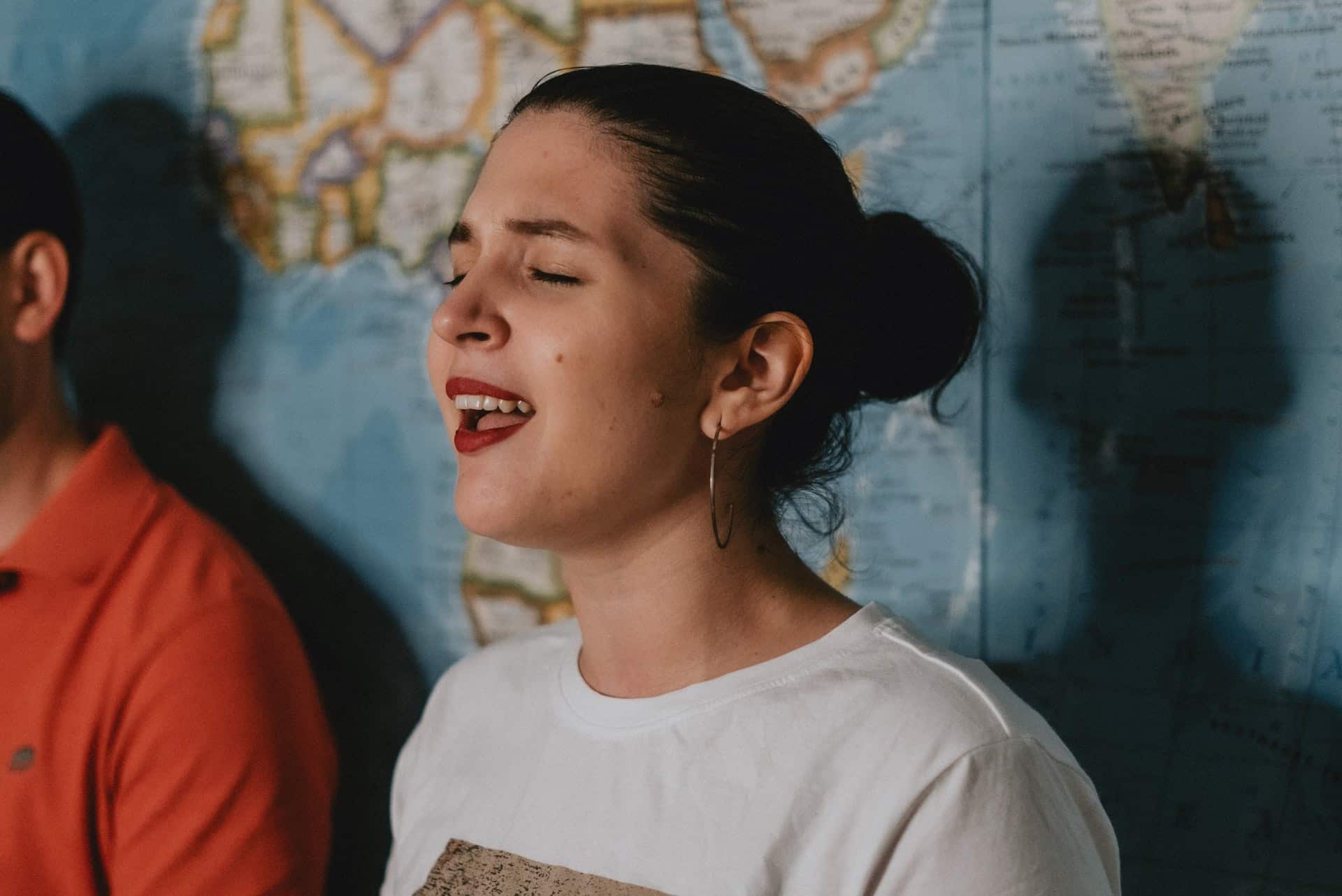 mulher cantando com os olhos fechados