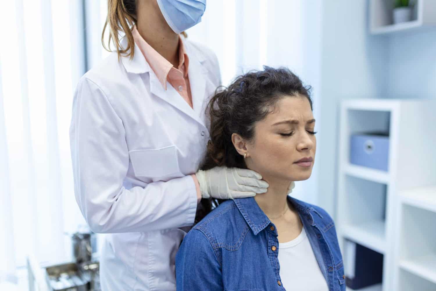 mulher sendo examinada da garganta por médica 