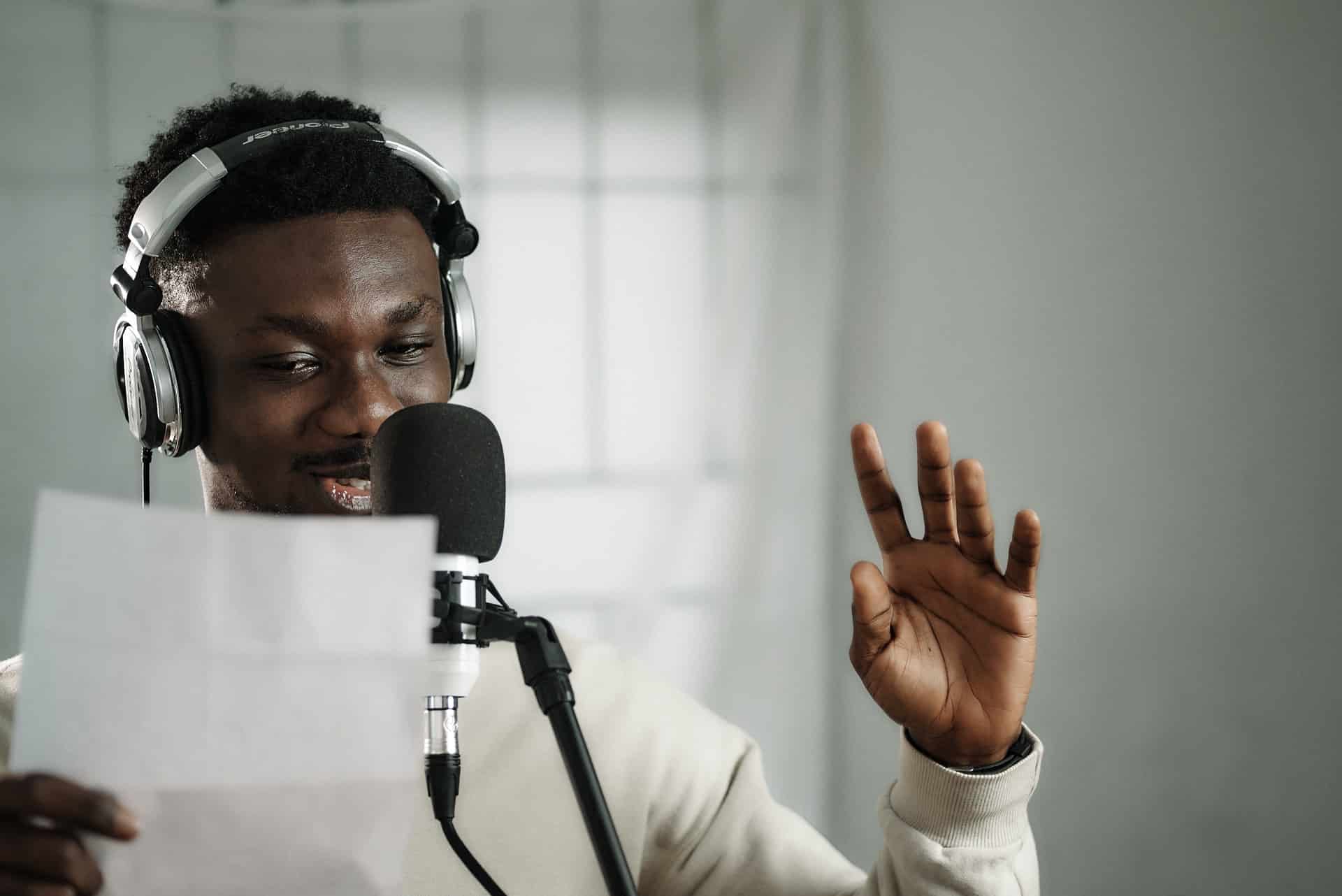 Jovem negro cantando uma cançao com papel e microfone