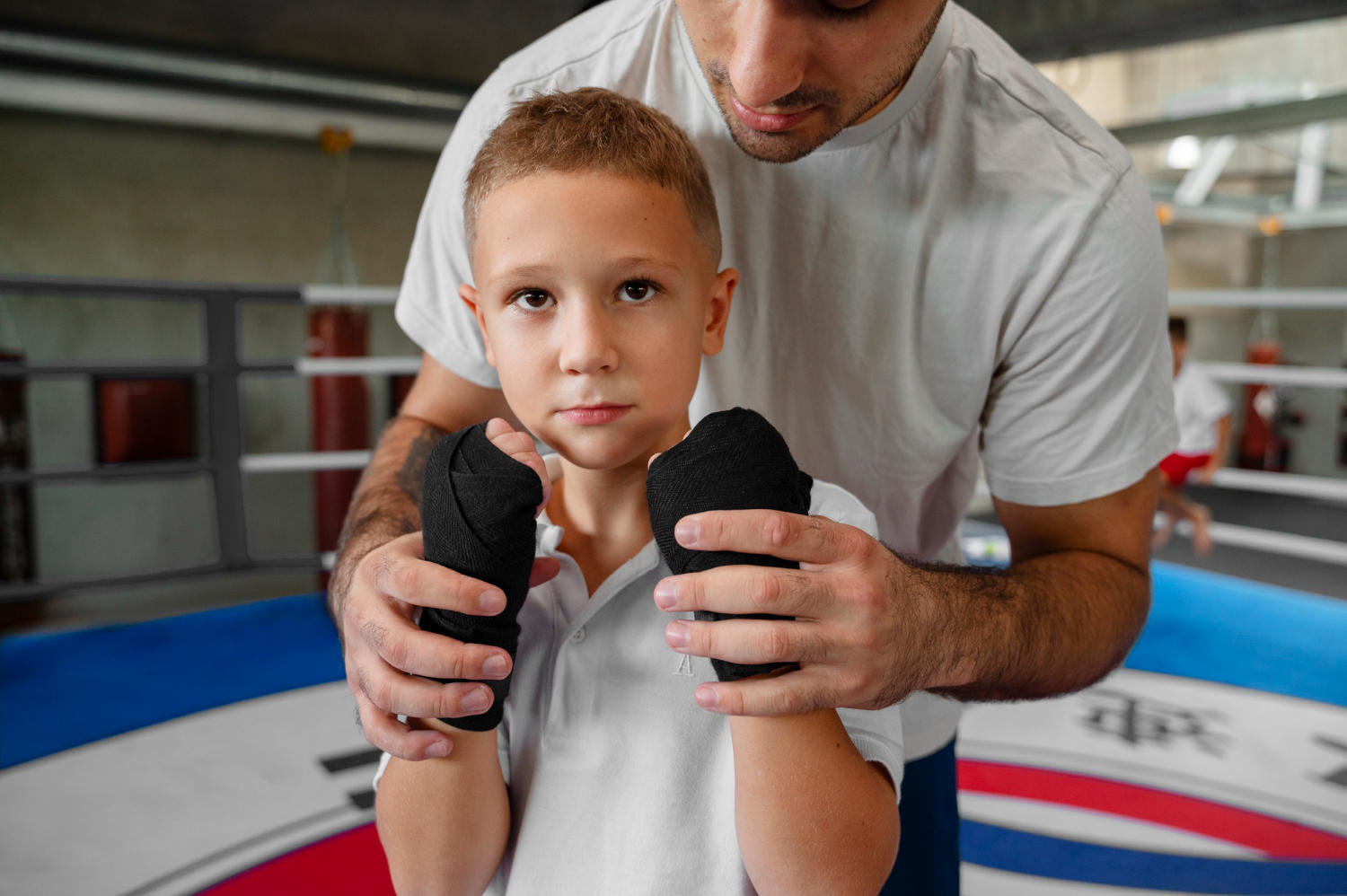 Professor ensinando criança a lutar boxe.