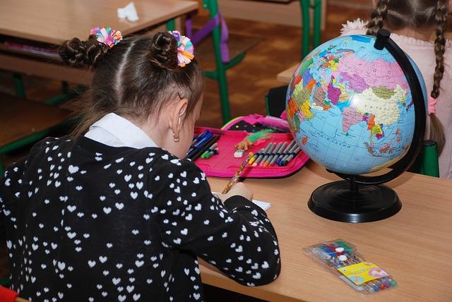 Criança estudando com globo terrestre.
