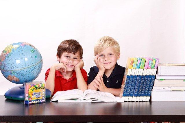 Dois meninos estudando geografia com um globo terrestre.