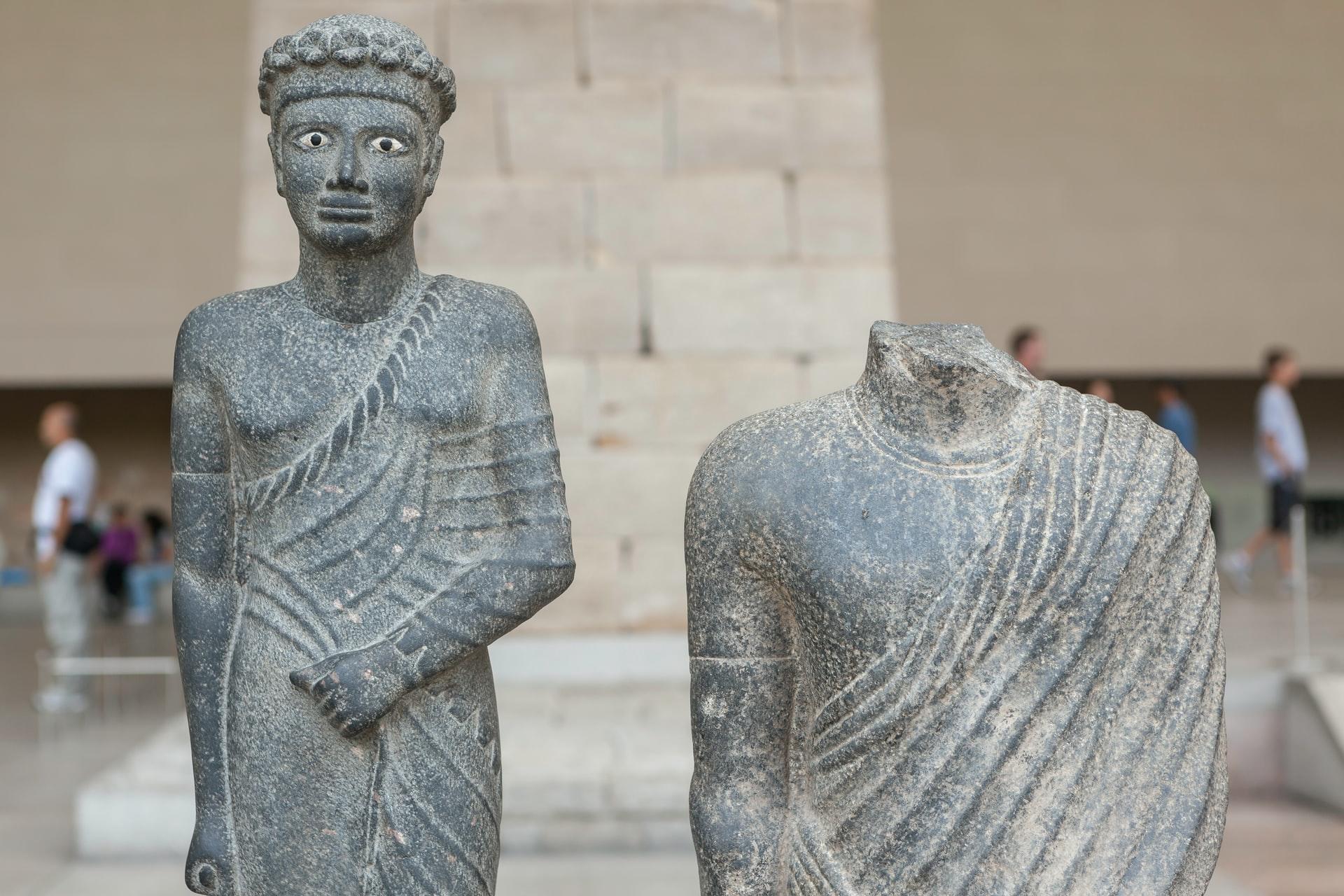 Duas estátuas egípcias de meados do século II a.C., sendo que uma delas está sem cabeça e que, possivelmente, indica um ofício sacerdotal.