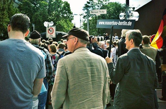 Grupo de pessoas reunidas na rua com placas e bandeiras.