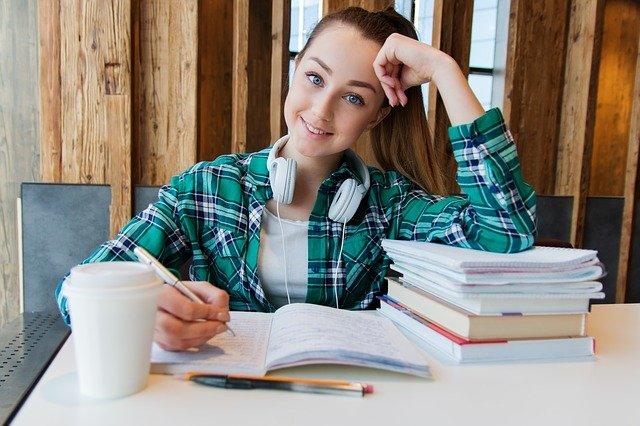 Estudante na biblioteca com livros.