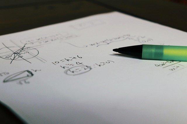 Lápis e papel com equações escritas