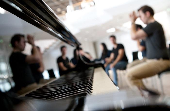 Um piano com pessoas em volta