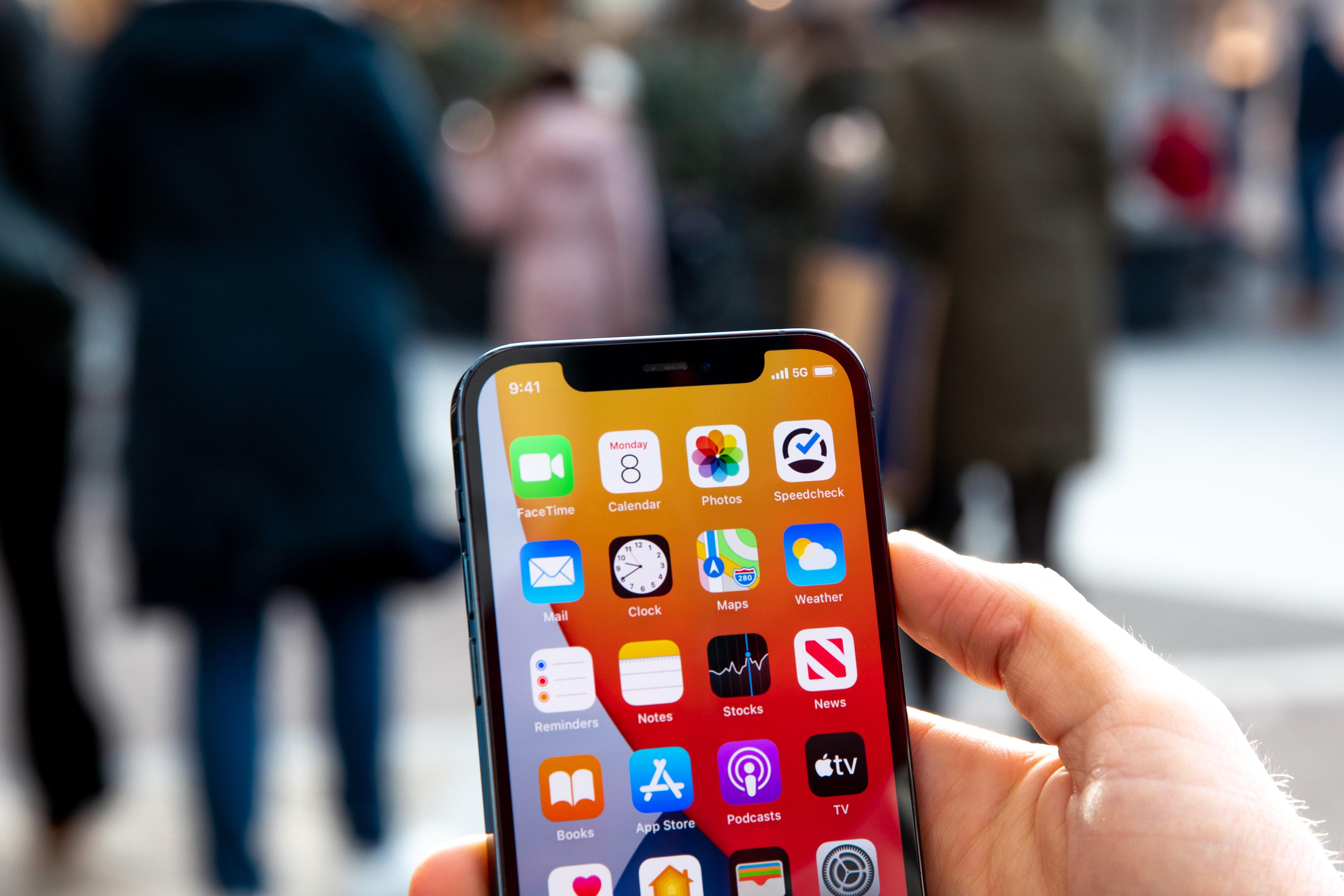 Uma mão está a segurar um celular com diversos aplicativos em destaque.