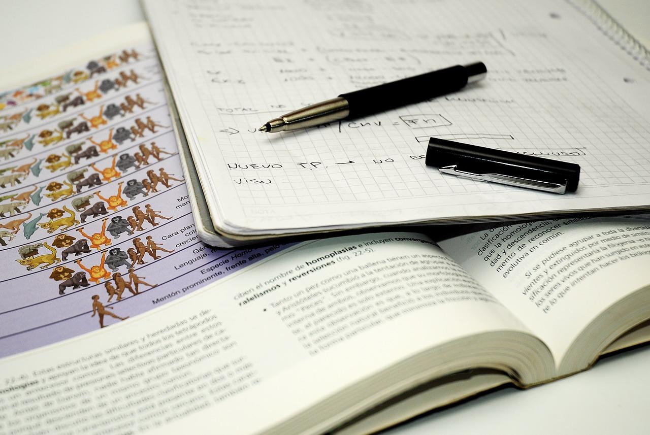 Cadernos e livros de biologia com uma caneta