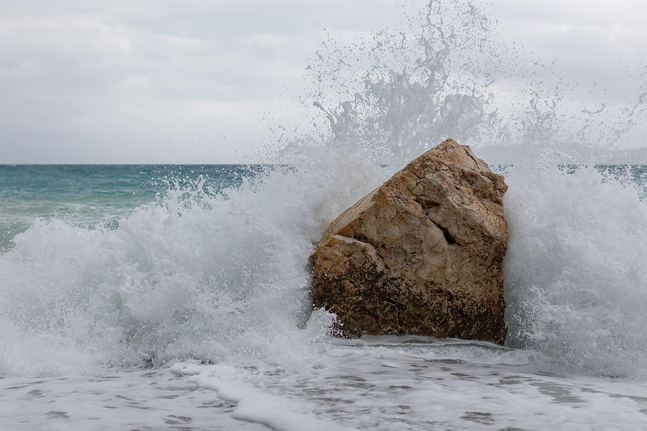 Uma onda batendo forte em uma pedra no oceano