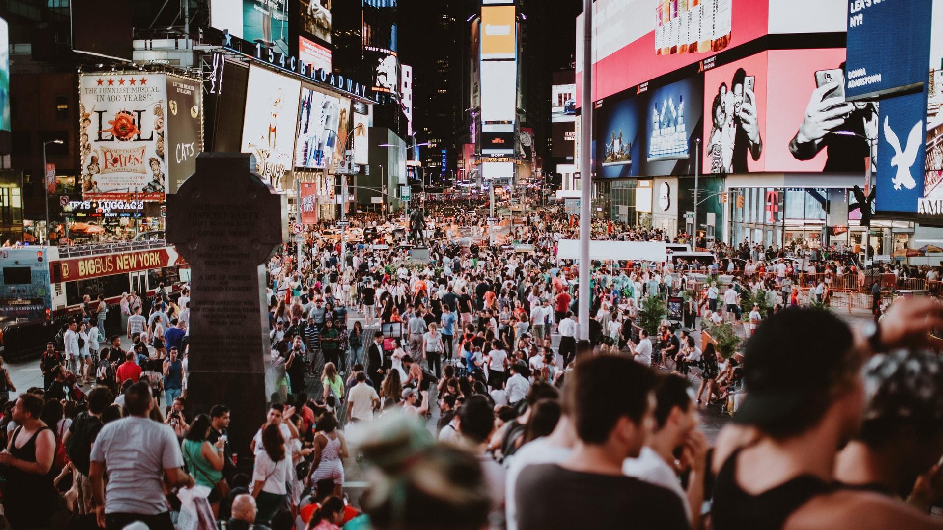 Imagem da Times Square, em Nova Iorque, cheia de gente.