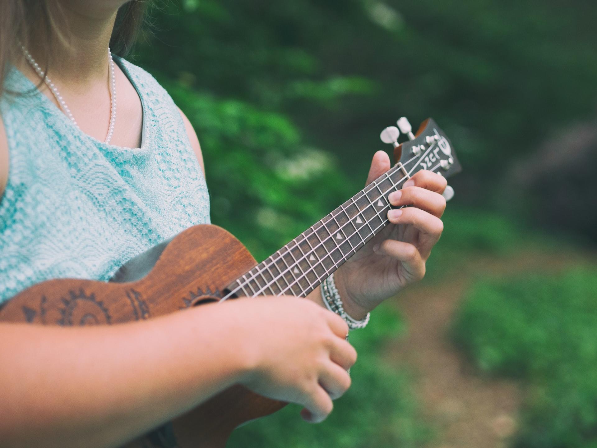 Mãos tocando o ukulele