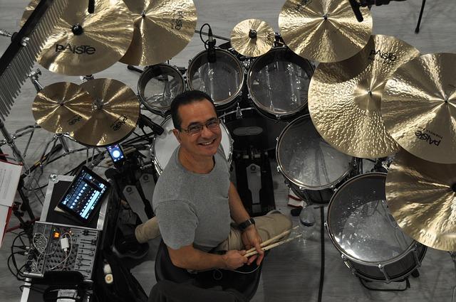 Bateria com muitos pratos e um baterista.