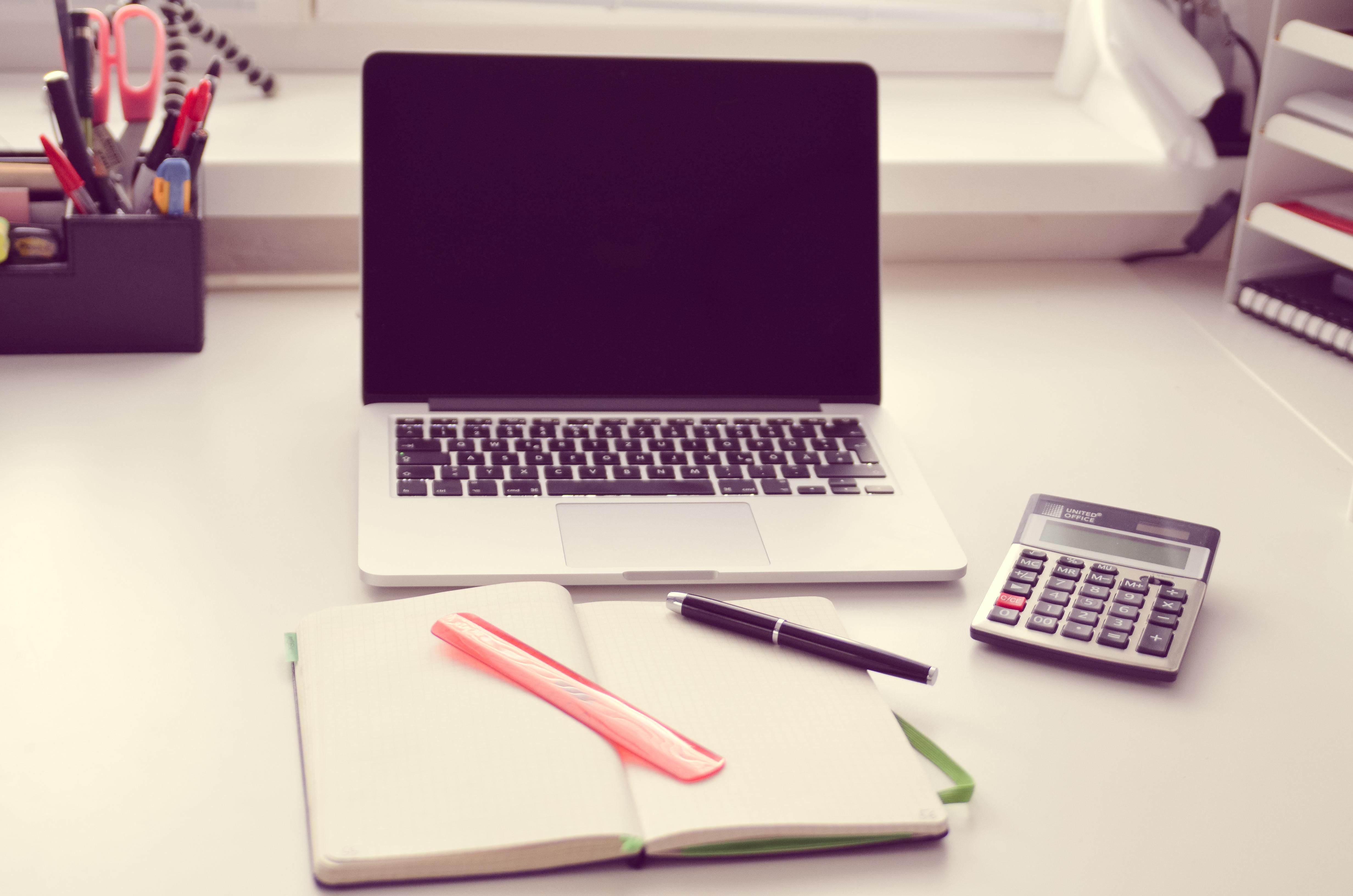 Notebook, calculadora e caderno para calcular o valor da aula de biologia