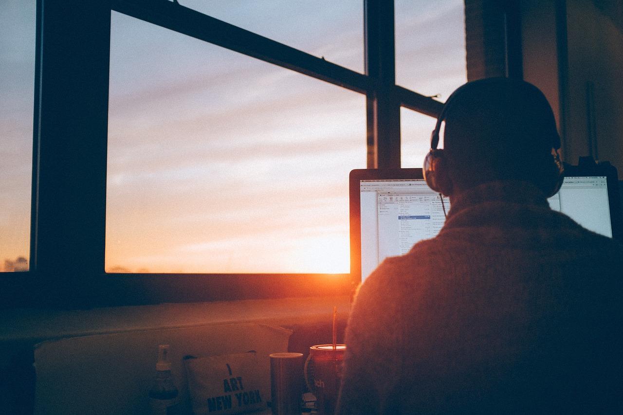 Um homem com fone de ouvido em frente ao computador