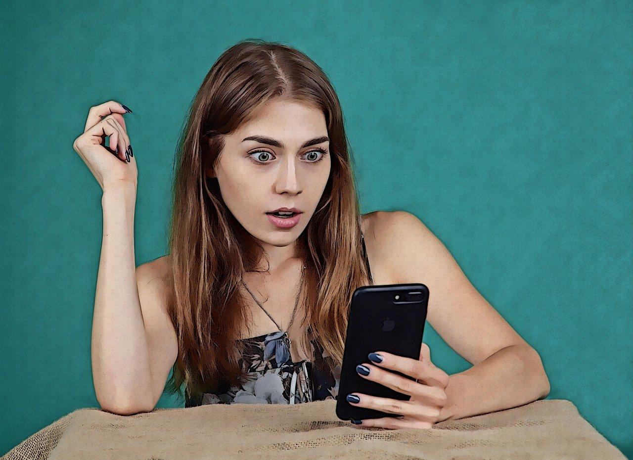 Menina assustada olhando o celular