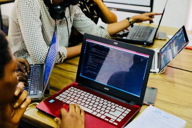 Grupo fazendo programação em computadores