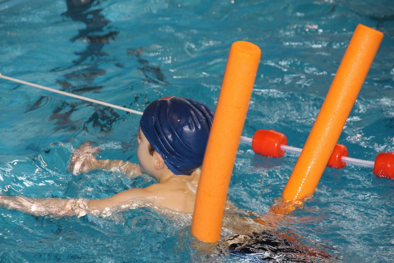 Criança com boia nadando na piscina