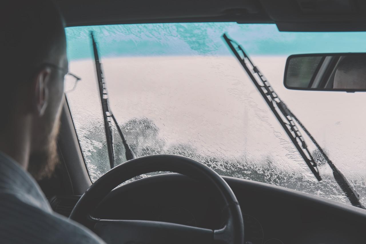 homem dirigindo um carro na chuva.