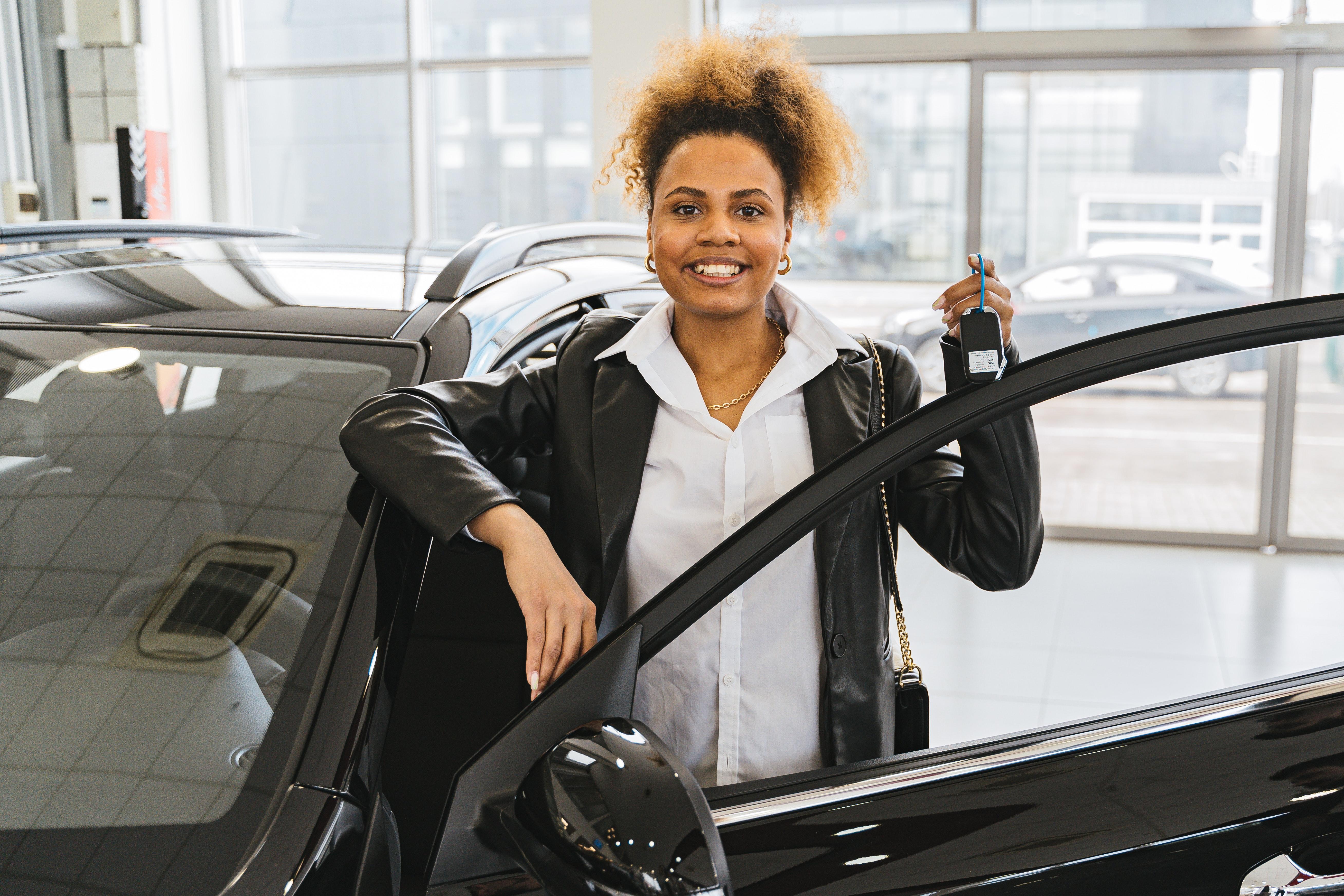 Uma mulher feliz com uma chave de carro na mão