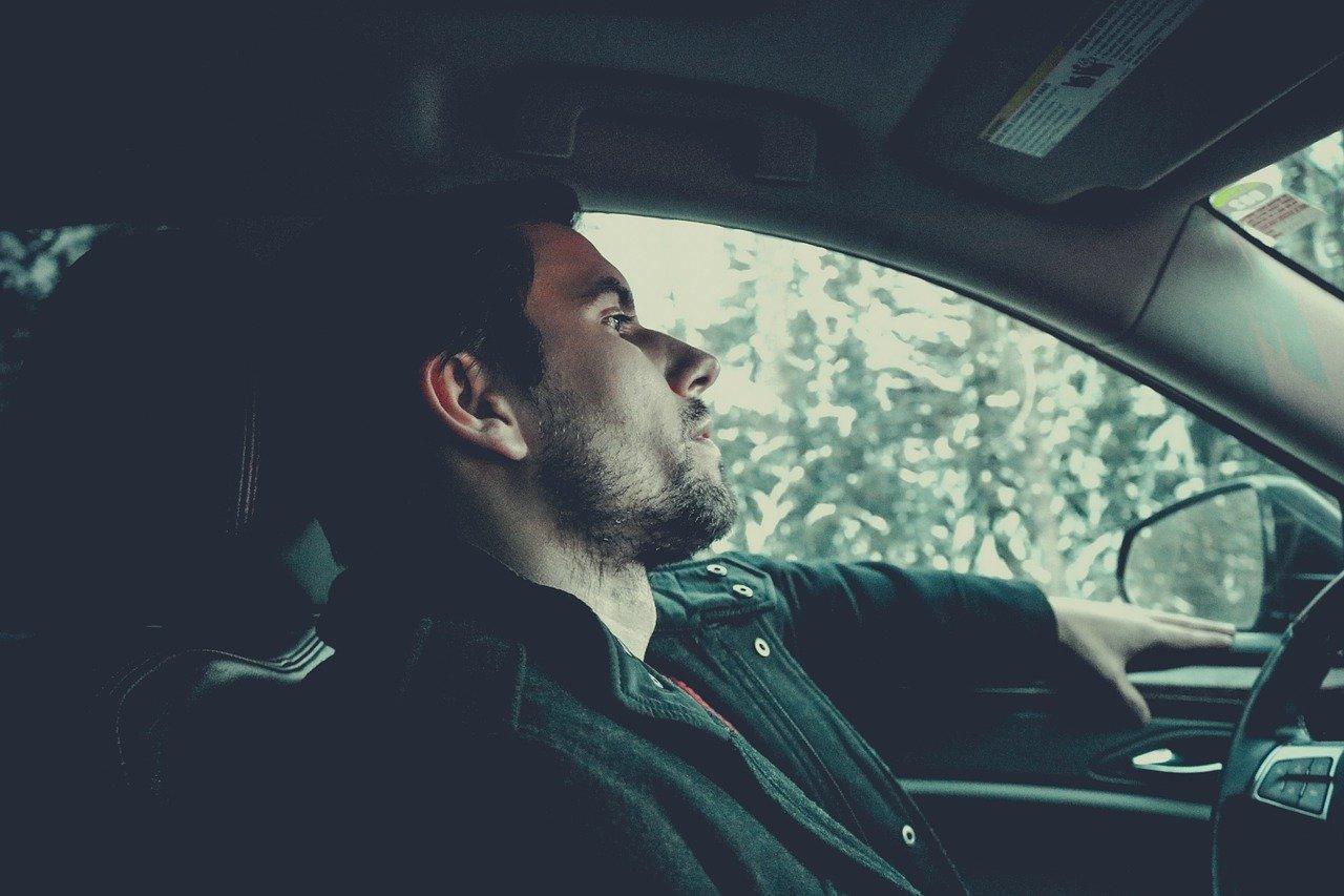 homem reflexivo em um carro