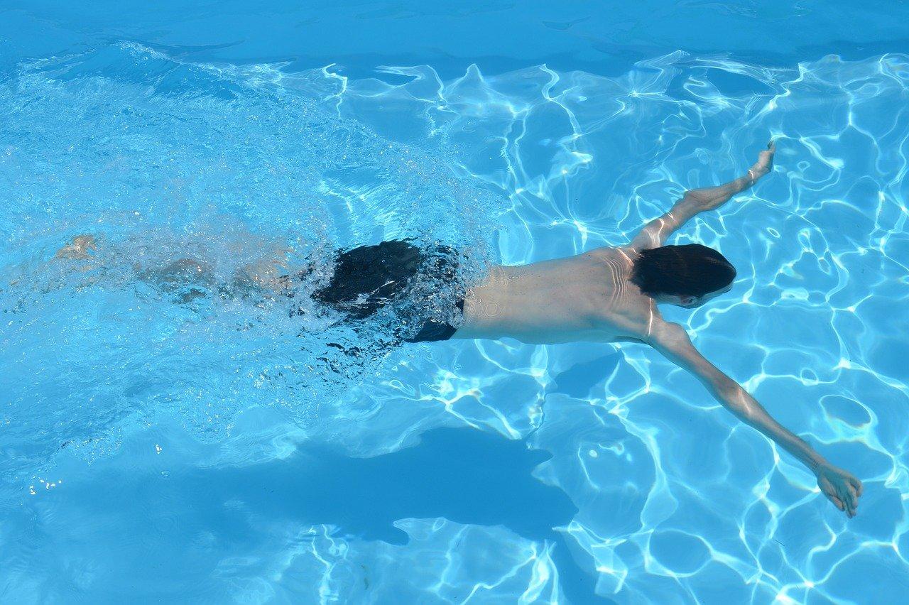 Menino mergulhando em piscina