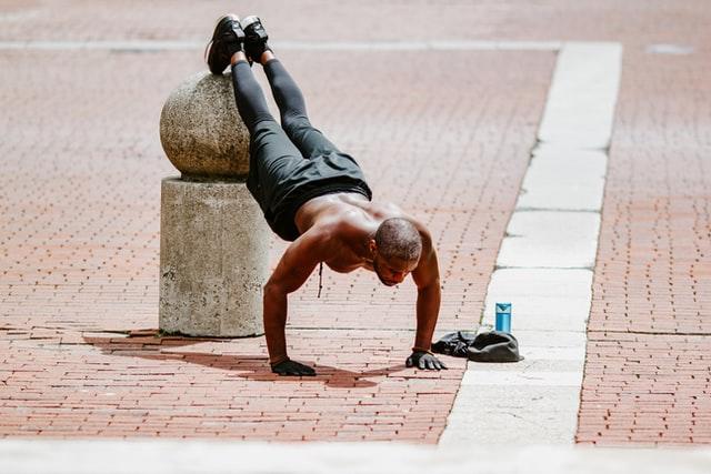 Homem faz flexão na rua