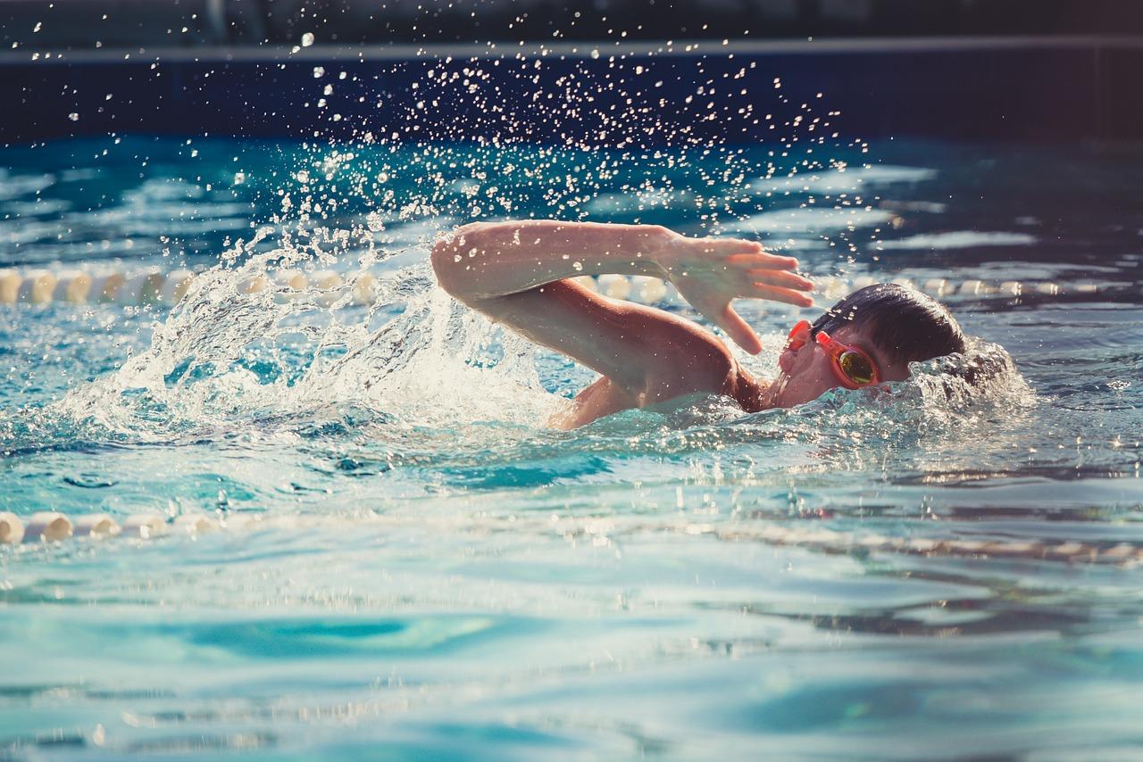 Uma criança nadando na piscina olímpica