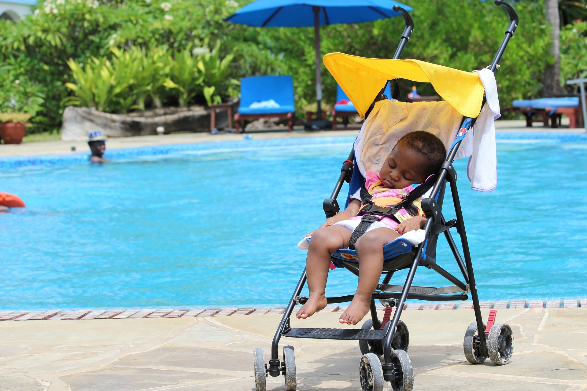 nenem dorme no carrinho perto da piscina