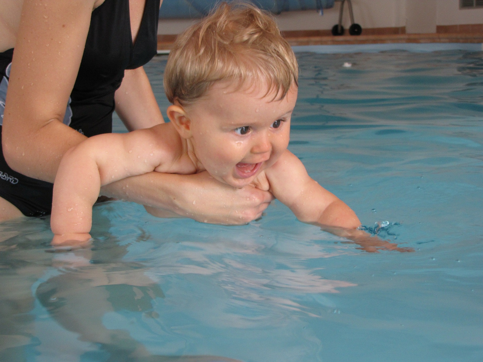 adulto segurando nenem na piscina