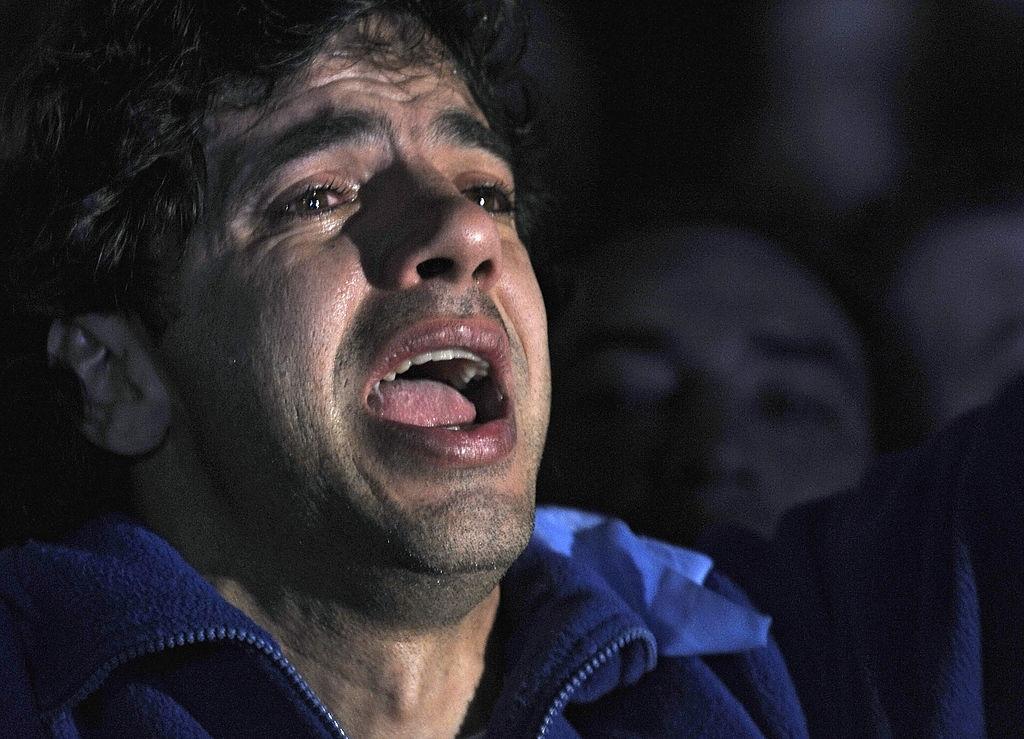 Imagem de um homem cantando emocionado o hino de seu país.