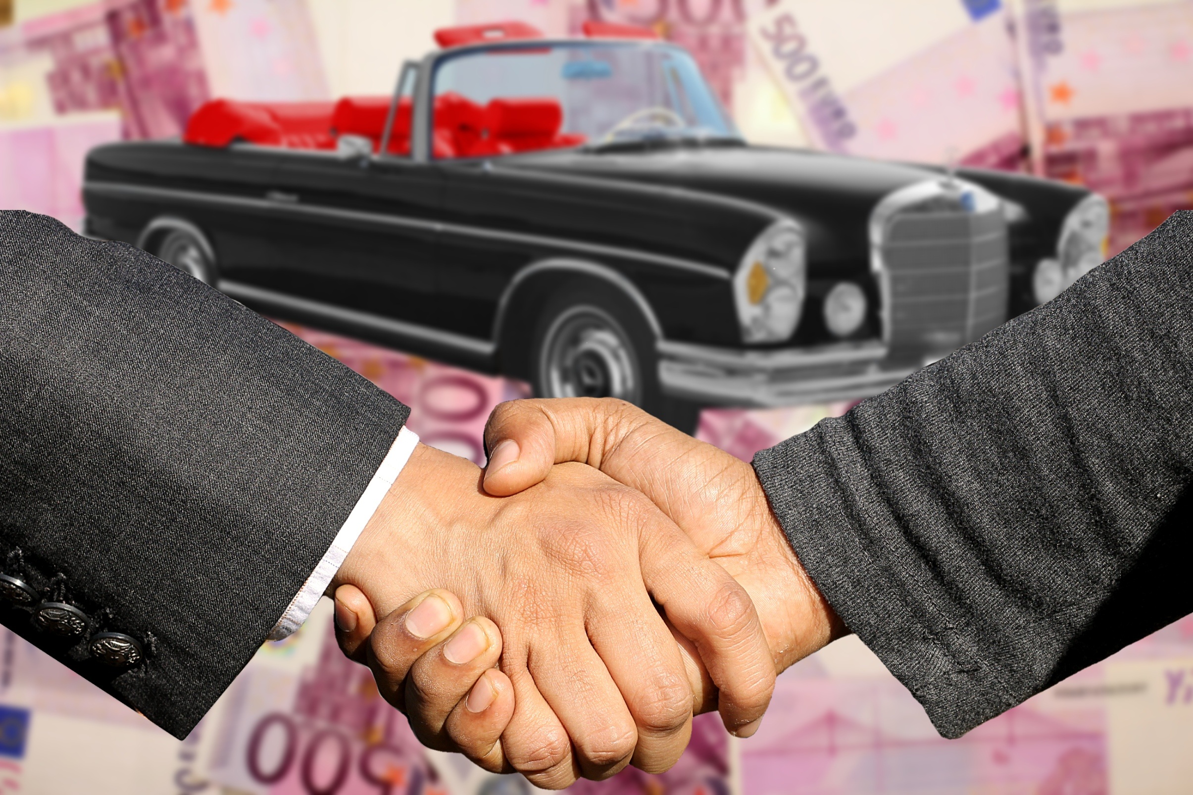 Duas pessoas fechando negócio em relação ao carro.