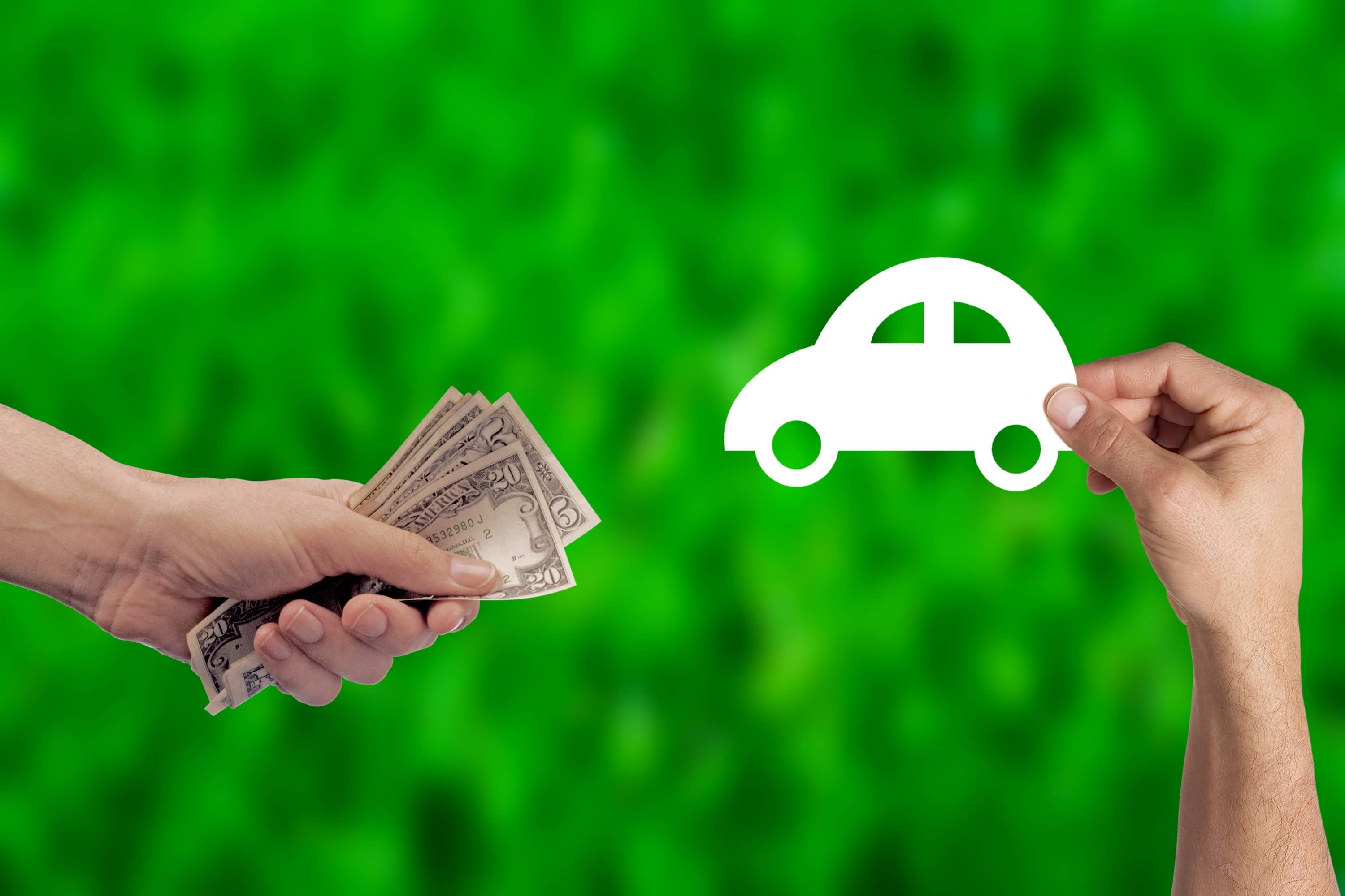 Uma pessoa com um carro de papel na mão e a outra segurando dinheiro.