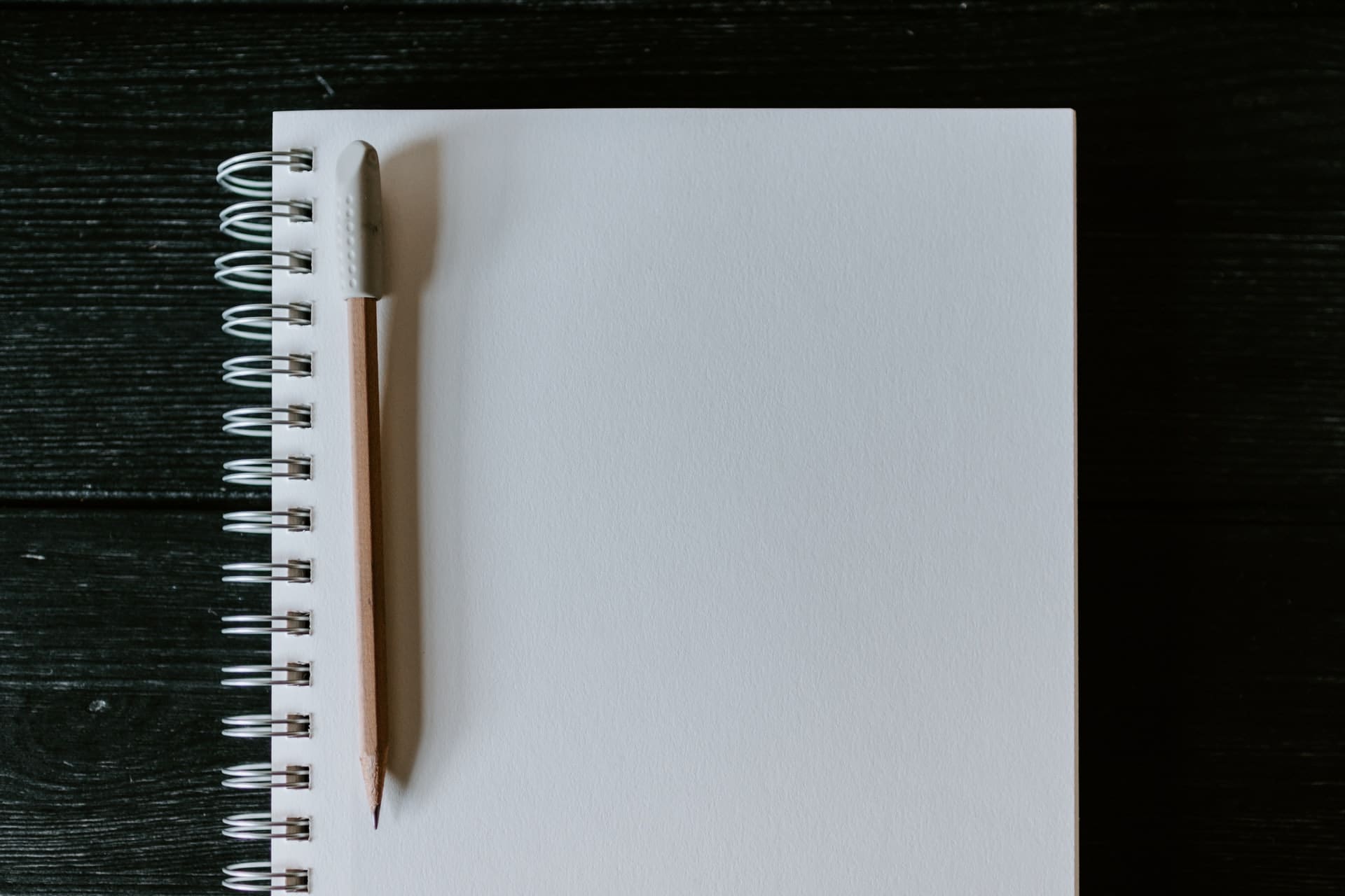 Caderno com folha em branco e lápis sobre a mesa